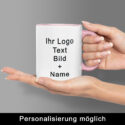 Zwei Hände halten einen weiß-rosa Keramikbecher, auf dem Logo, Text, Bild und Name platziert werden können – anschauliches Beispiel, wie sich einen Becher bedrucken lassen individuell umsetzen lässt