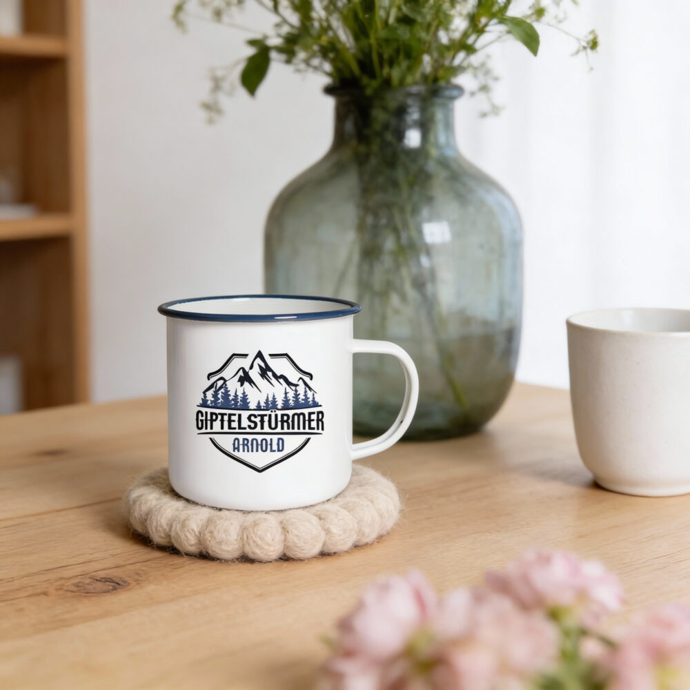 Emaillebecher blauer Rand mit Logo-Druck Emaillebecher mit blauem Rand und Berg-Logo auf Holztisch mit Vase und Blumen